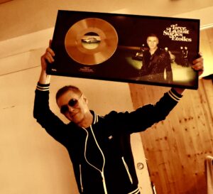 Etienne Daho tenant le disque d'or de son album 'Tirer la nuit sur les étoiles', reçu en mai 2024.